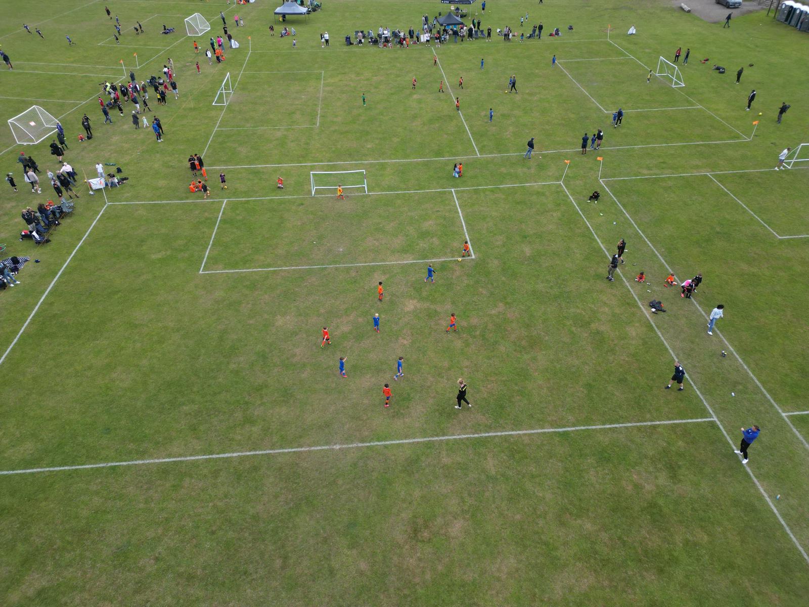 Drone shot of a match in progress with crowds along the touchline