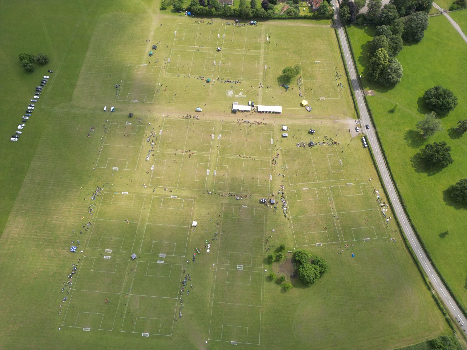 Drone view of Henley Showground filled with pitches, tents and players